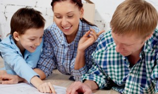 A little boy and his parents sitting together and looking at house plans.