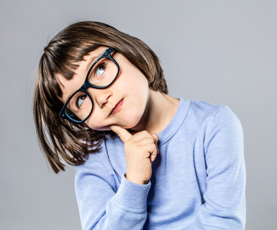 thoughtful little girl wearing eyeglasses, holding her head to the side and thinking