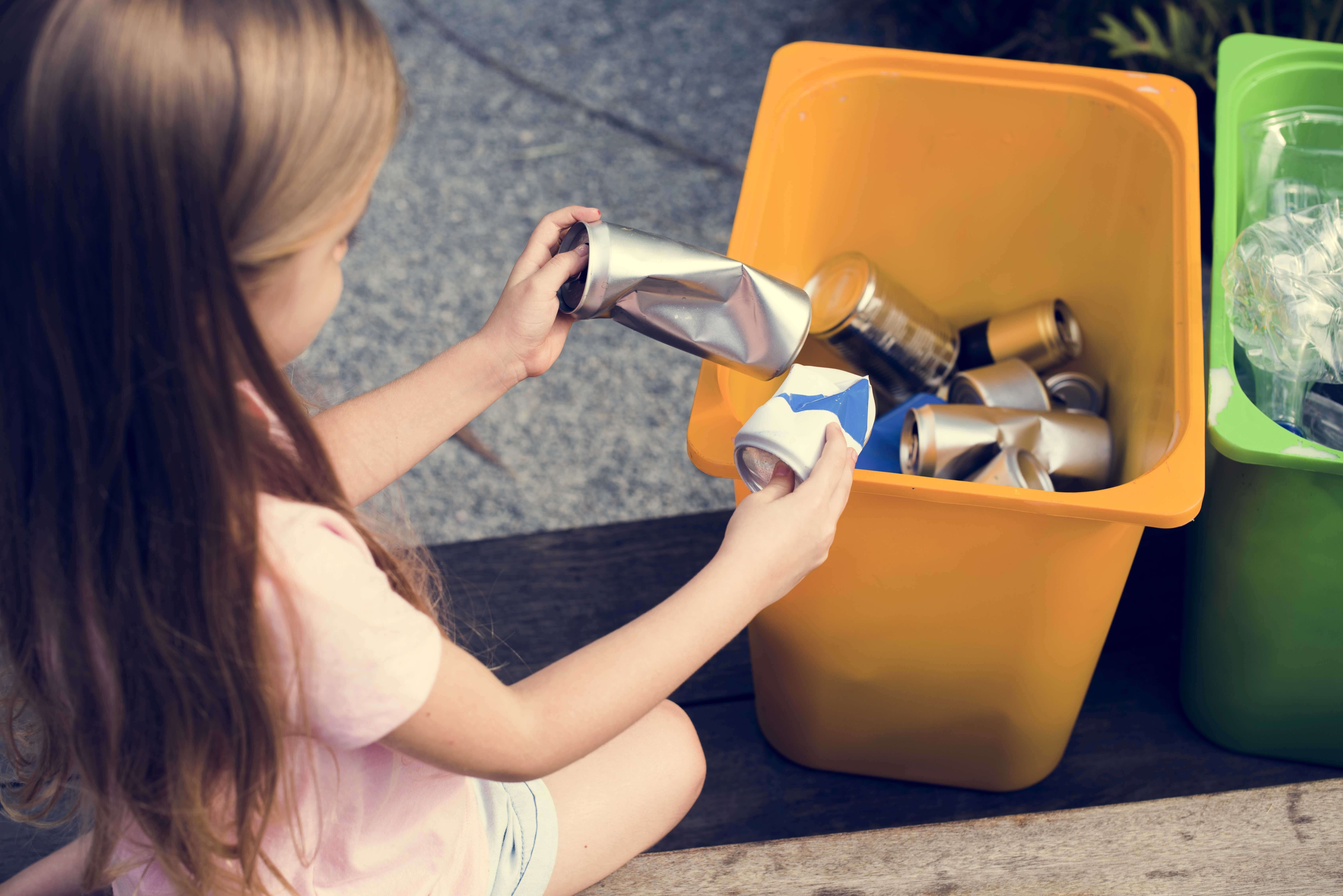 A girl sorts through recycled materials.