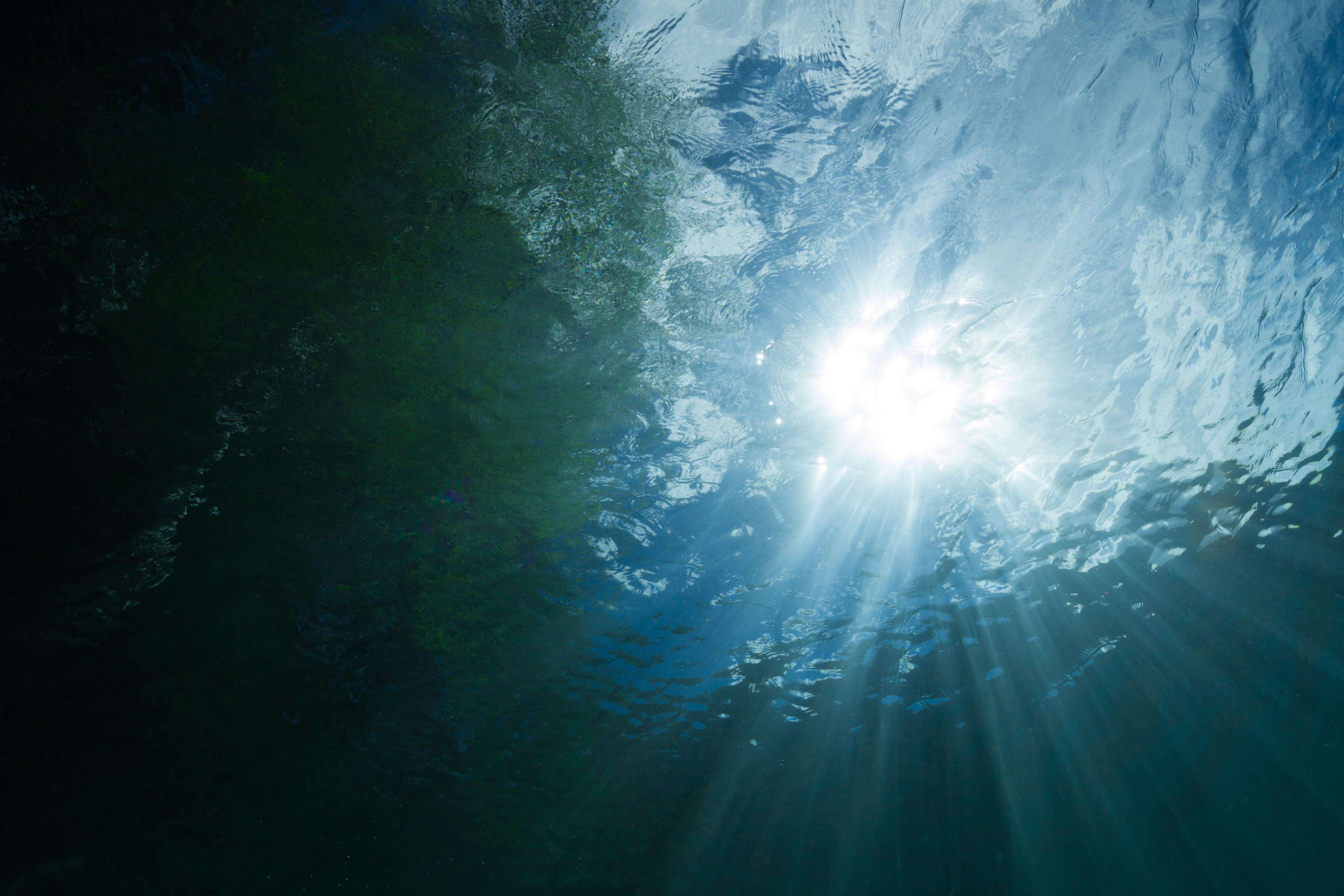 Sunlight streaming down below the surface of the ocean.