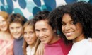 Group of smiling teenagers standing in front of a colorful background