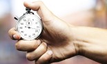 hand holding stopwatch against an abstract background