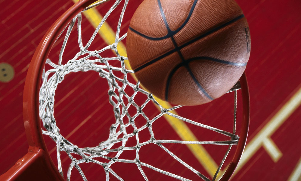 Close-up of basketball going into a basketball hoop