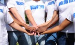 Multi-ethnic volunteer group put hands together, showing unity