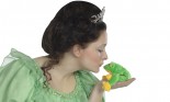 Young woman dressed in a princess costume kissing a frog