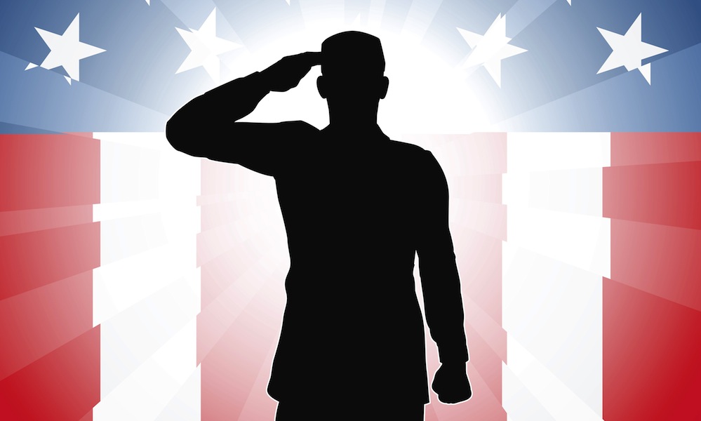Silhouette of a patriotic soldier saluting in front of an American flag