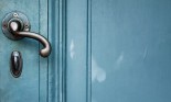 Single door handle on old door painted with blue