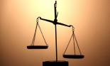 Gold scales of justice on brown background