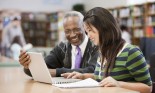 Librarian helping student do research in school library