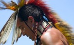 Profile of a Native American wearing a feathered headdress