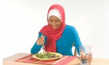 Female student wearing a hijab eating a salad