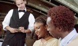 Waiter taking couple's order in restaurant, smiling