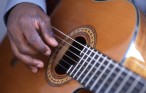 Close up of man playing guitar.