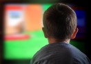 Young boy watching a television screen