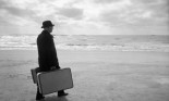 Man Carrying Suitcases at Beach