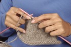 Hands knitting natural colored yarn