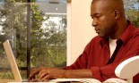 Man sitting at dining room table with laptop