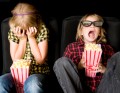 Frightened boy and girl wearing 3D glasses in a movie theater