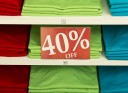 40% off sign with t-shirts in a pile on a store shelf