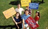 Racially mixed ethnic group of teen boy and girl students showing protest signs: recycling, ozone, whales, redwoods