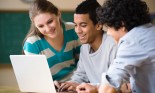 Teenage students (14-17 years old) using laptop together