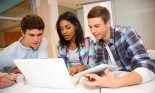 Group of students (18 years old) working on laptop in classroom