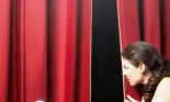 Actor peeking through theatre curtains