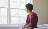 Teenage boy looking out window