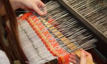 Woman working at the loom, with focus on the fabric