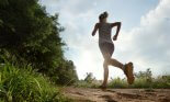 Young lady running on a rural road during sunset