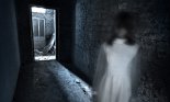 Horror movie scene with a blurry female figure in a white dress in a hallway