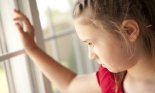 Sad Young Girl Looking Out of Window