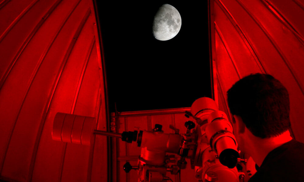 Man in observatory looking at the moon
