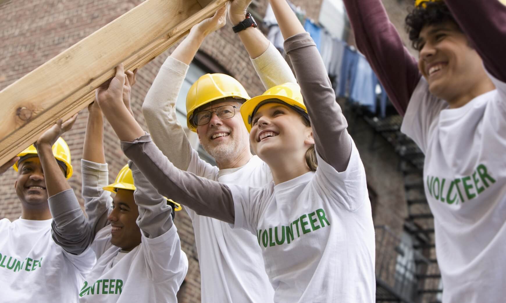 Volunteers lifting construction frame together
