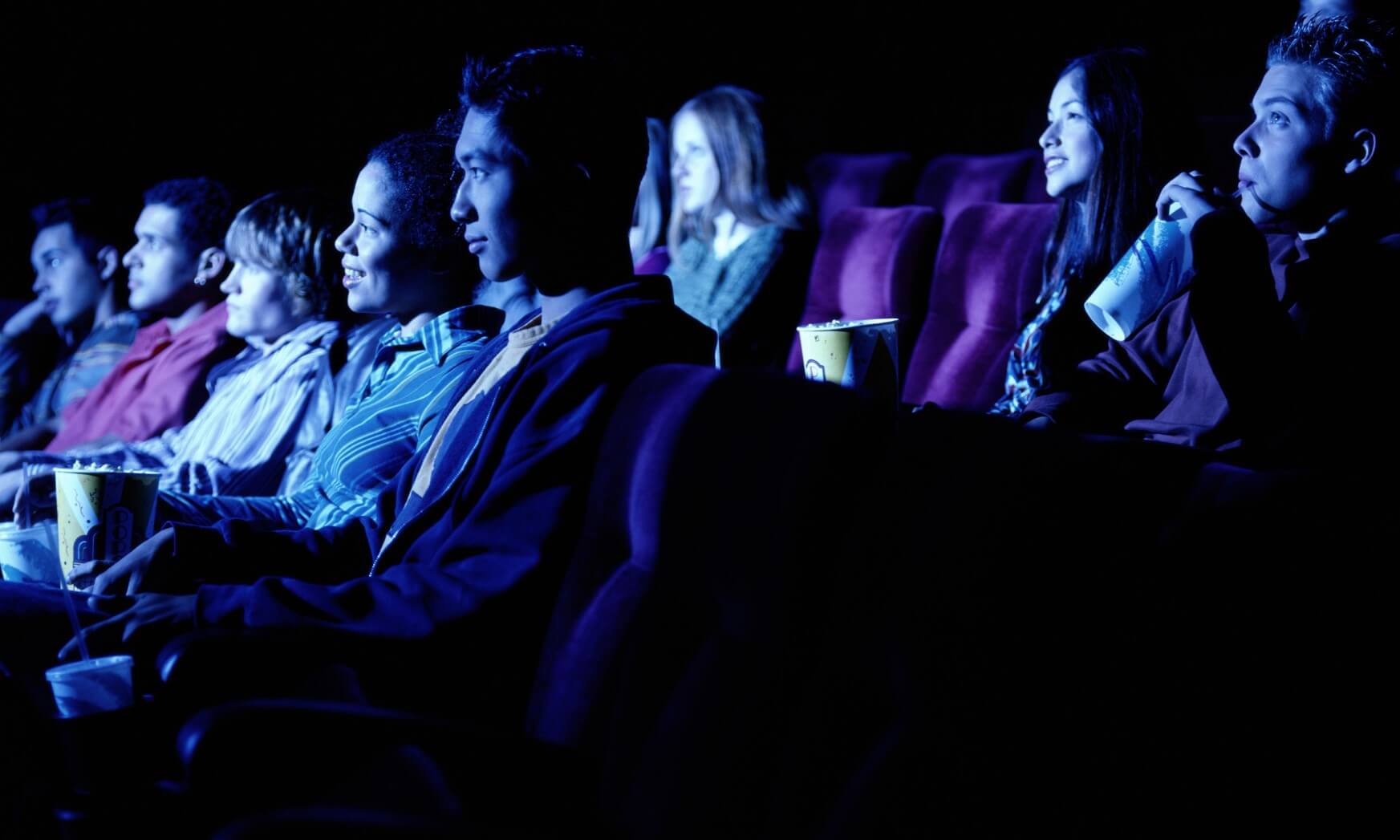 Group of young people watching movie, side view