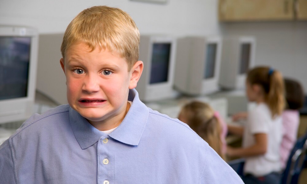 Boy in a classroom making a scared face