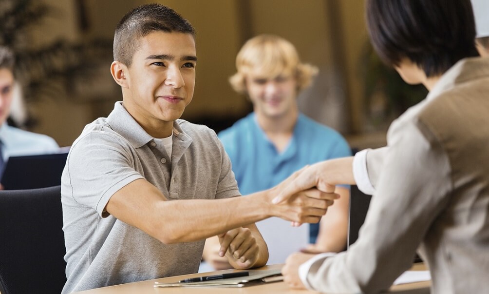 High school student shaking hands at a job or college interview