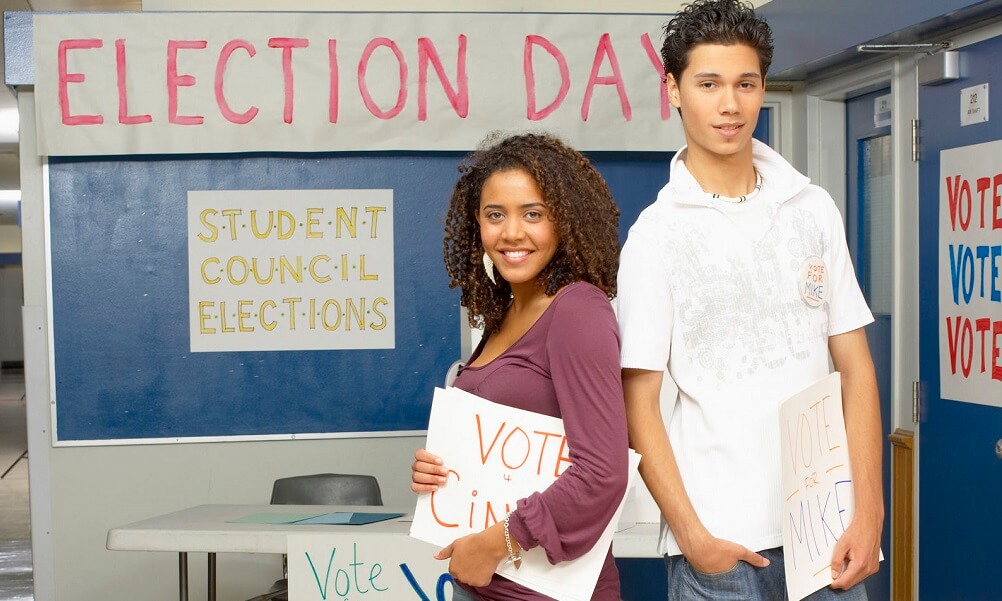 Two teenagers standing in a hall on student council election day