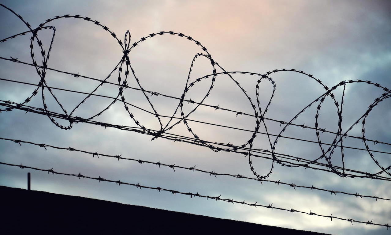 Barbed wire fence stretched around prison walls