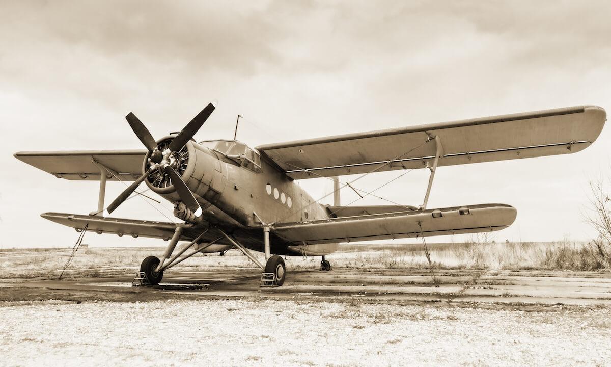 Old airplane on field in sepia tone