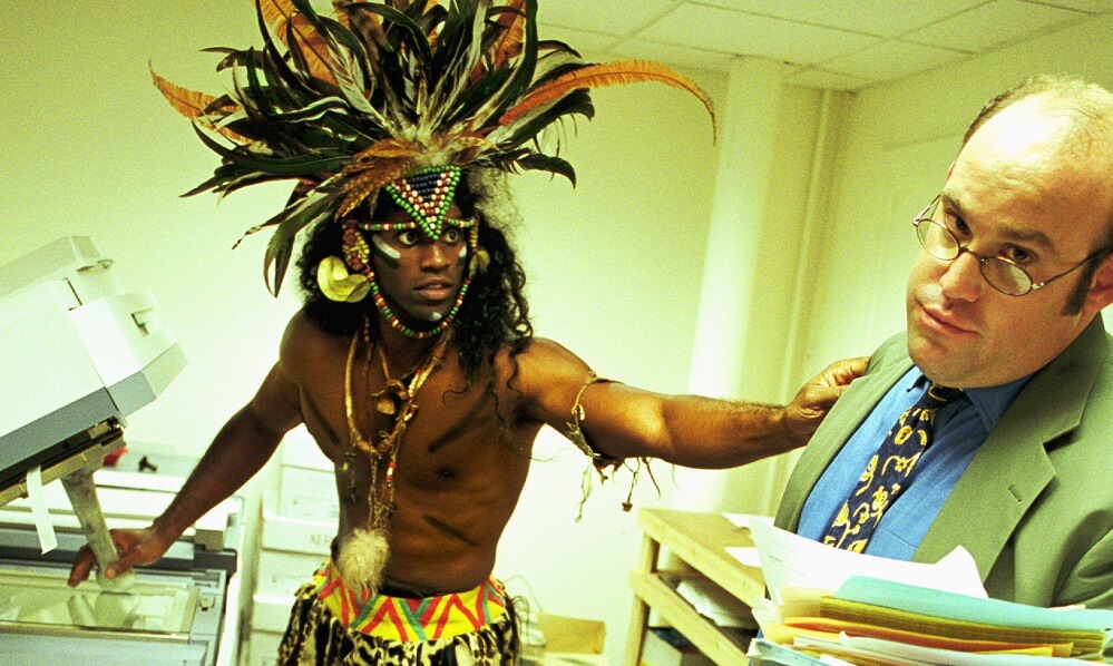 Men dressed as tribesman and businessman in an office