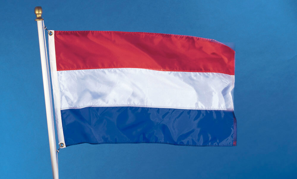 National flag of the Kingdom of the Netherlands on flagpole, waving