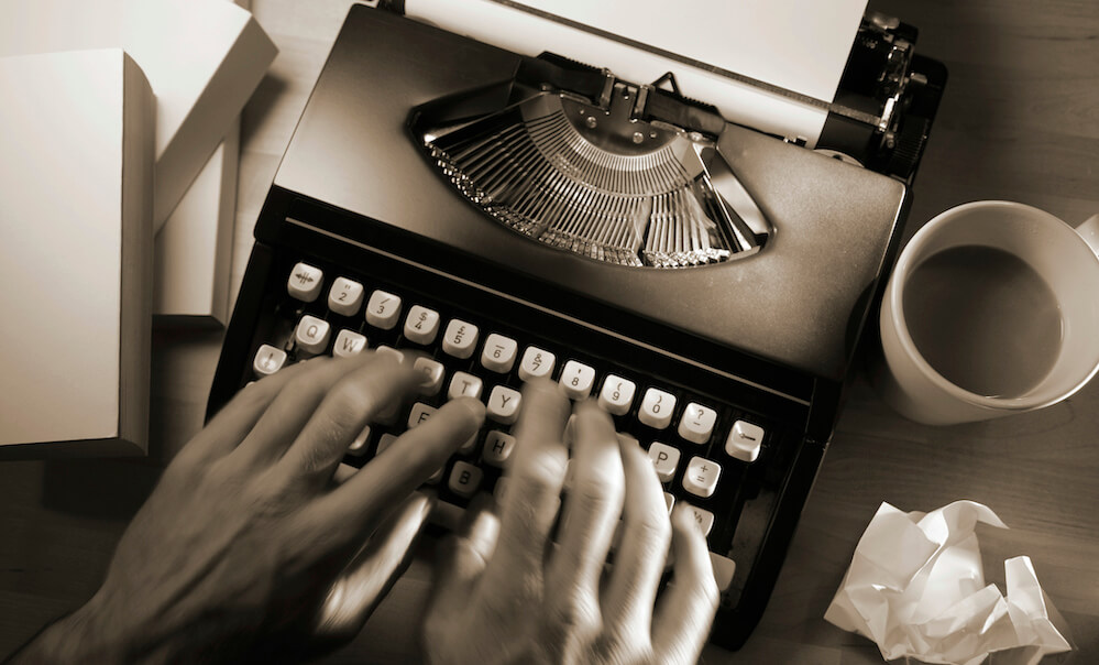 Hands typing on typewriter keyboard