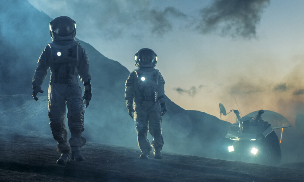 Two astronauts walking on an alien planet with a rover vehicle in the background