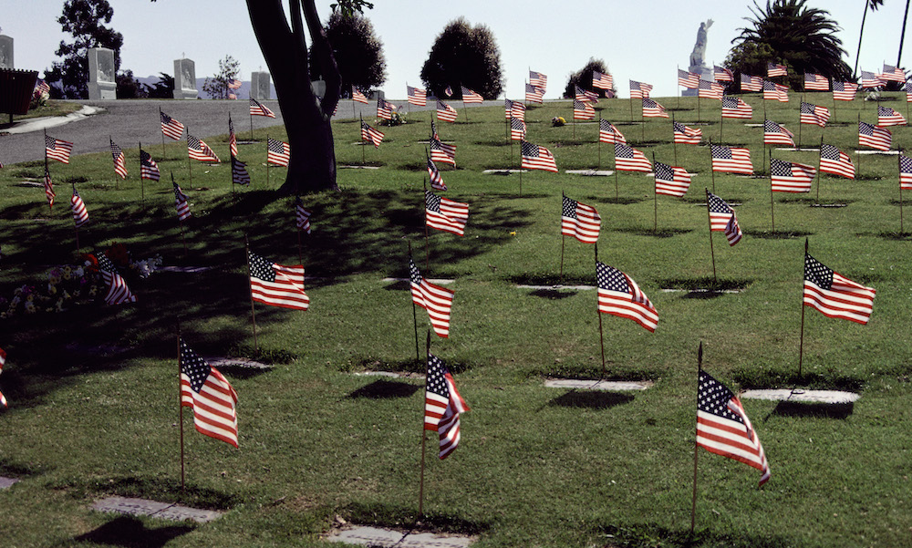 Flags flying at gravesites in a military veterans cemetery