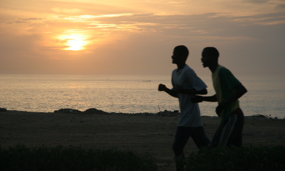 Two men running as the sun rises.