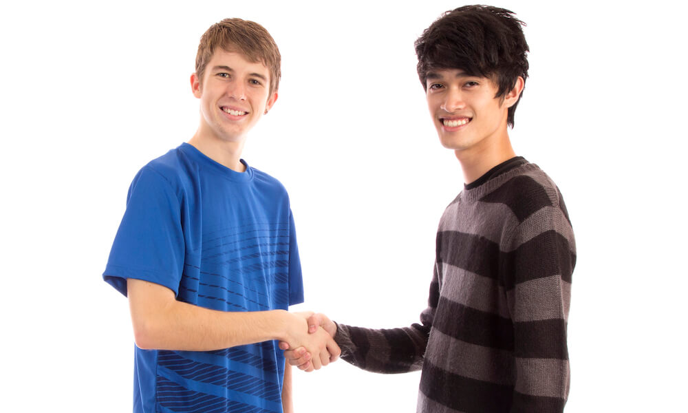 Two teenage boys shaking hands
