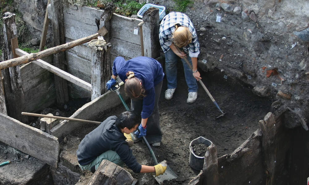 Overhead view of three archeologists at work