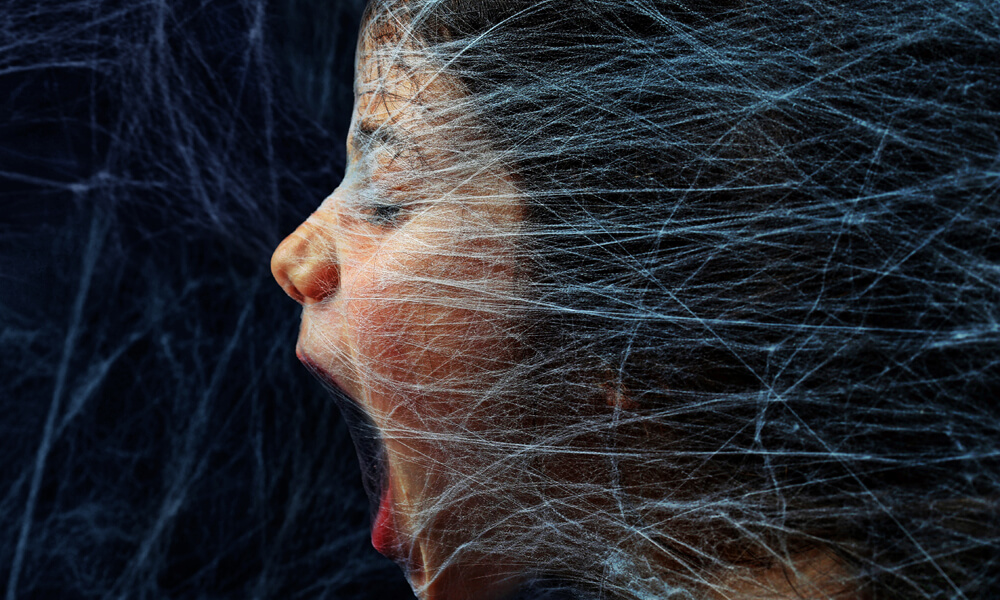 Scared girl trapped in a spider web