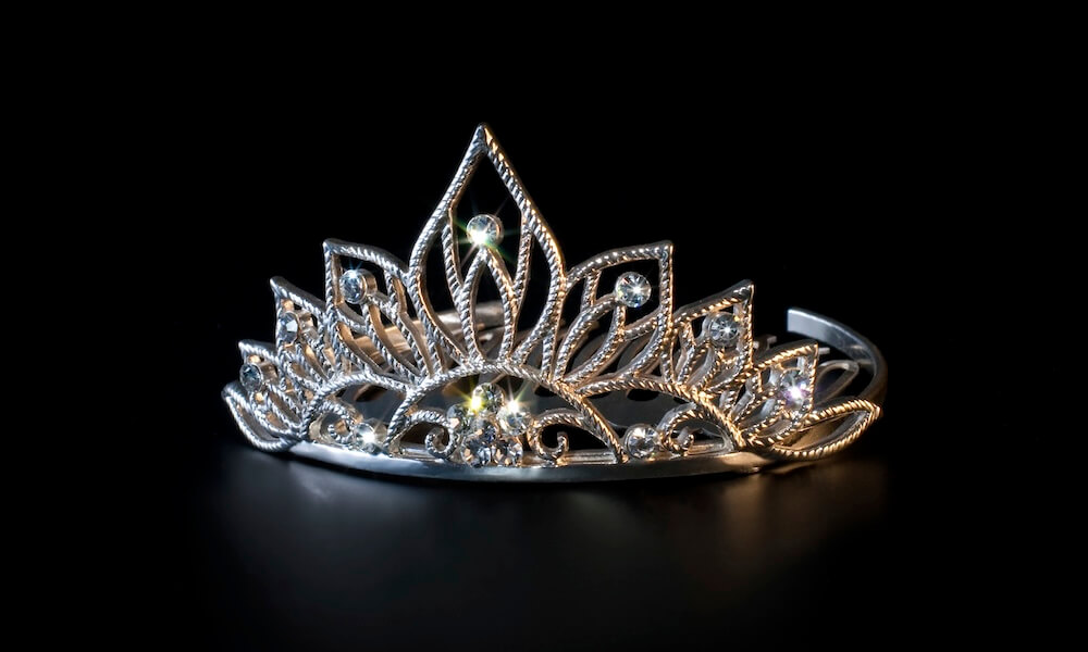 A tiara with diamonds against a black background.